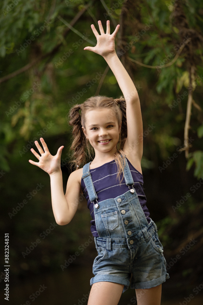 Beautiful little girl blonde child in denim overalls outdoors Stock Photo |  Adobe Stock