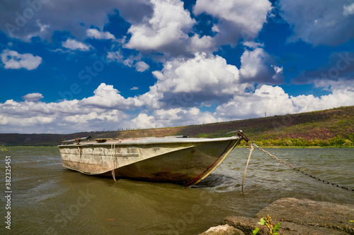 Canvastavla Old metal fishing boat moored in the shallow waters of the river