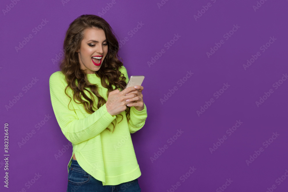 Excited Young Woman Is Holding Telephone, Looking At It And Shouting. Excited Young Woman Is Holding Telephone, Looking At It And Shouting.
