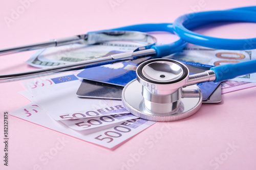 Фотография stethoscope, credit cards and euro banknotes on pink background, concept of impa