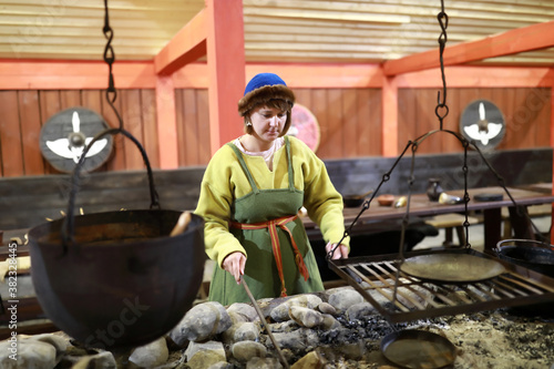 Woman in viking clothes cooking food