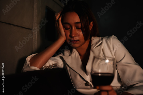 Drunk business woman sleeping on a couch after drinking red wine too much. © THESHOTS.CO