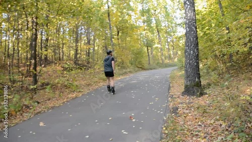 Wallpaper Mural A man is rollerblading on an asphalt track in the autumn forest. Torontodigital.ca