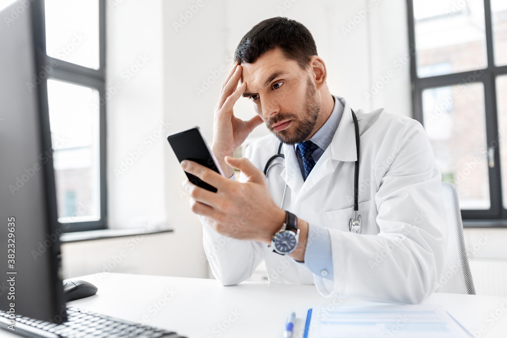 healthcare, medicine and people concept - male doctor with smartphone at hospital healthcare, medicine and people concept - male doctor with smartphone at hospital