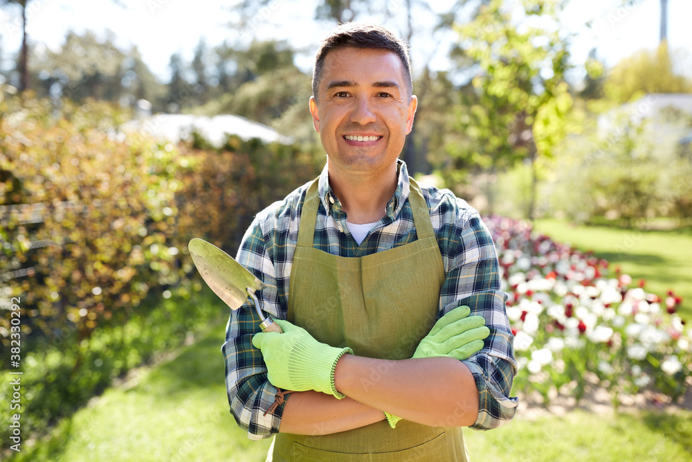© Syda Productions - gardening and people concept - happy smiling middle-aged man in apron with trowel in crossed hands at summer garden © Syda Productions - gardening and people concept - happy smiling middle-aged man in apron with trowel in crossed hands at summer garden