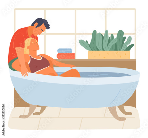 Pregnancy preparing, wife and husband joint birth. Pregnant woman giving natural birth in a bathtube full of water in bathroom interior. Active position use to reduce pain during childbirth