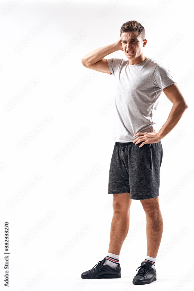 Athletic man on a light background in full growth and jogging charging shorts sneakers t-shirt Athletic man on a light background in full growth and jogging charging shorts sneakers t-shirt