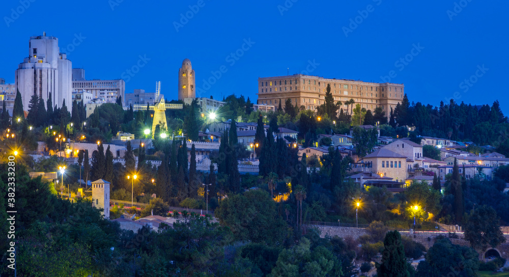 Blue hour at Mishkenot Shaananim and Yemin Moshe, first Jewish neighborhoods outside Jerusalem's Old City, with Montefiore Windmill, the YMCA tower and historic King David hotel on top of the hill