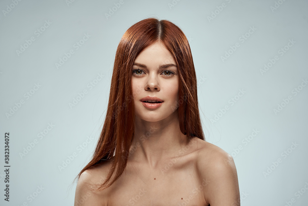 beautiful red-haired woman naked shoulders cosmetics long hair glamor light background beautiful red-haired woman naked shoulders cosmetics long hair glamor light background