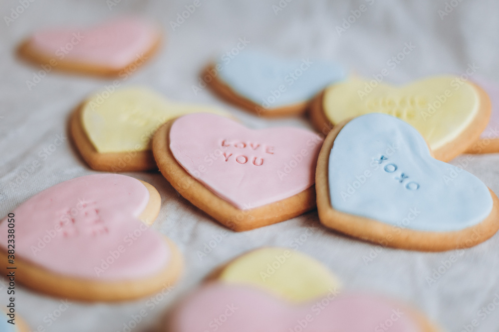 Valentine's Day presents: Heart-shaped cookies with colorful glaze and themed lettering for all lovers Valentine's Day presents: Heart-shaped cookies with colorful glaze and themed lettering for all lovers