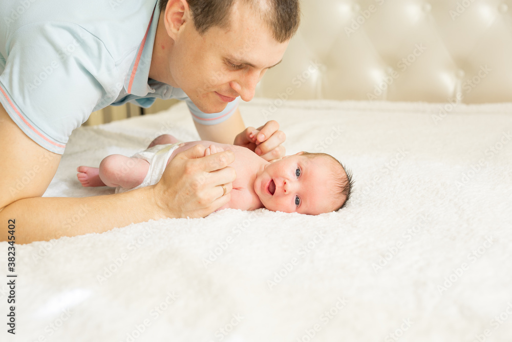 Woman and man giving a newborn baby. Mom, dad and baby. Close-up. Portrait of a young smiling family with a newborn baby in their arms. Happy family on the background. Woman and man giving a newborn baby. Mom, dad and baby. Close-up. Portrait of a young smiling family with a newborn baby in their arms. Happy family on the background.