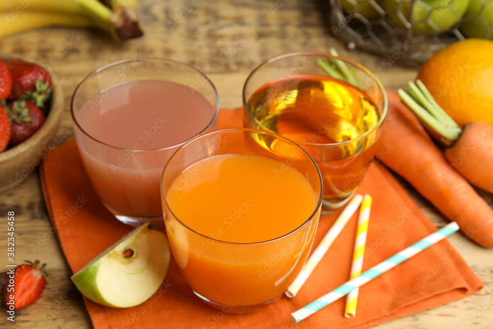 Glasses of delicious juices and fresh fruits on wooden table Glasses of delicious juices and fresh fruits on wooden table
