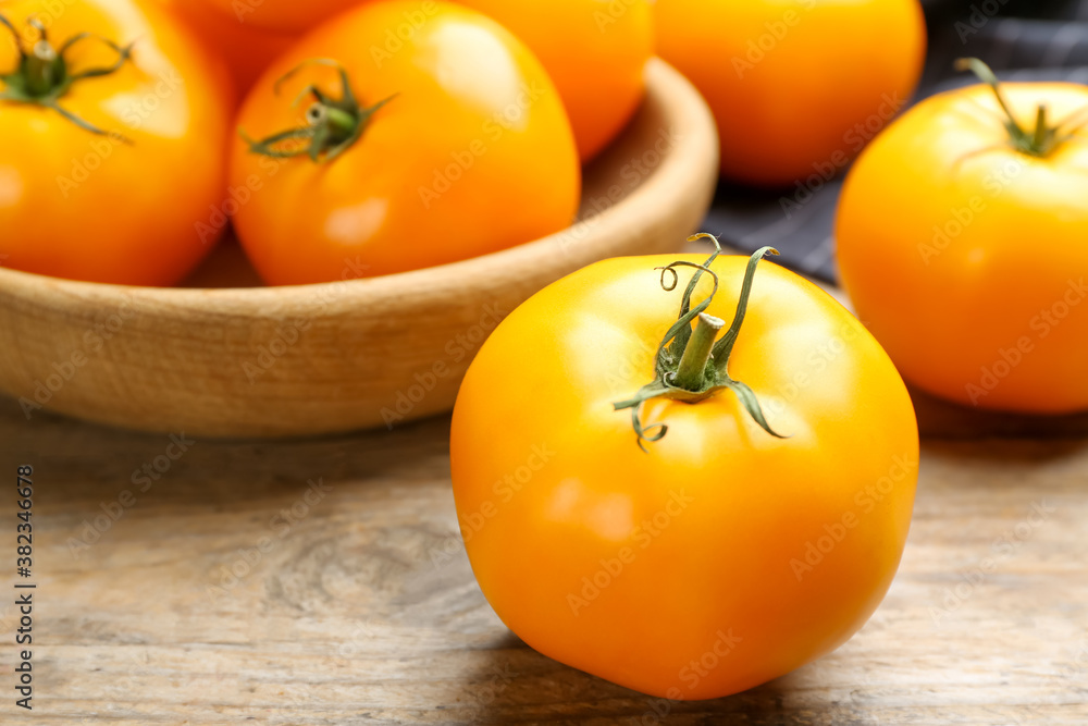 Ripe yellow tomato on wooden table, closeup Ripe yellow tomato on wooden table, closeup