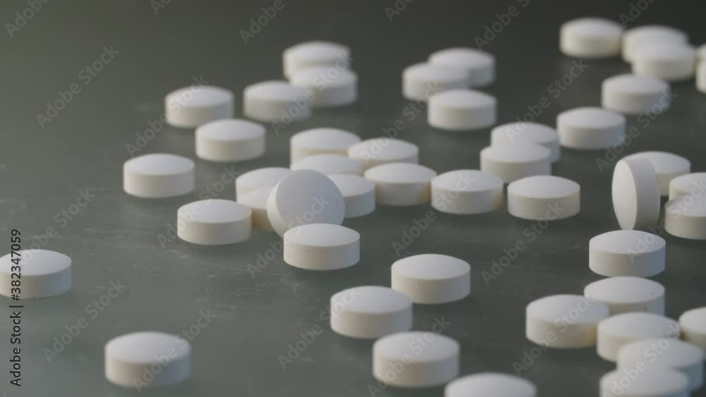 Extreme close up medical tablets and pills on grey background. Healthcare medicaments. Medical drugs on table. Camera slowly moving on slider, dolly shot, macro Extreme close up medical tablets and pills on grey background. Healthcare medicaments. Medical drugs on table. Camera slowly moving on slider, dolly shot, macro