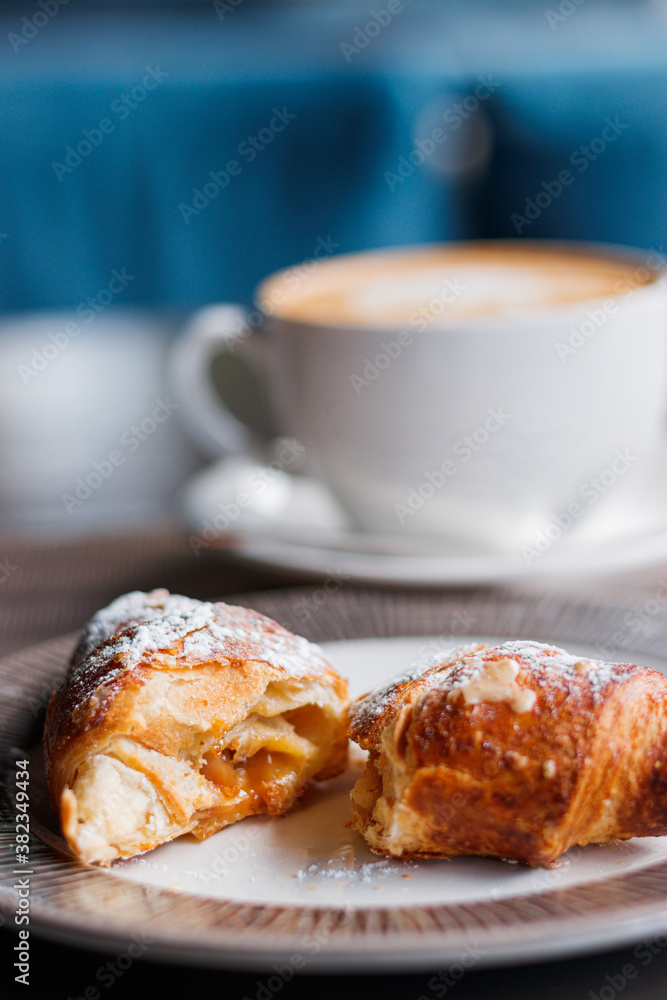 morning coffee with a croissant on the summer terrace. Breakfast with cup of cappuccino morning coffee with a croissant on the summer terrace. Breakfast with cup of cappuccino