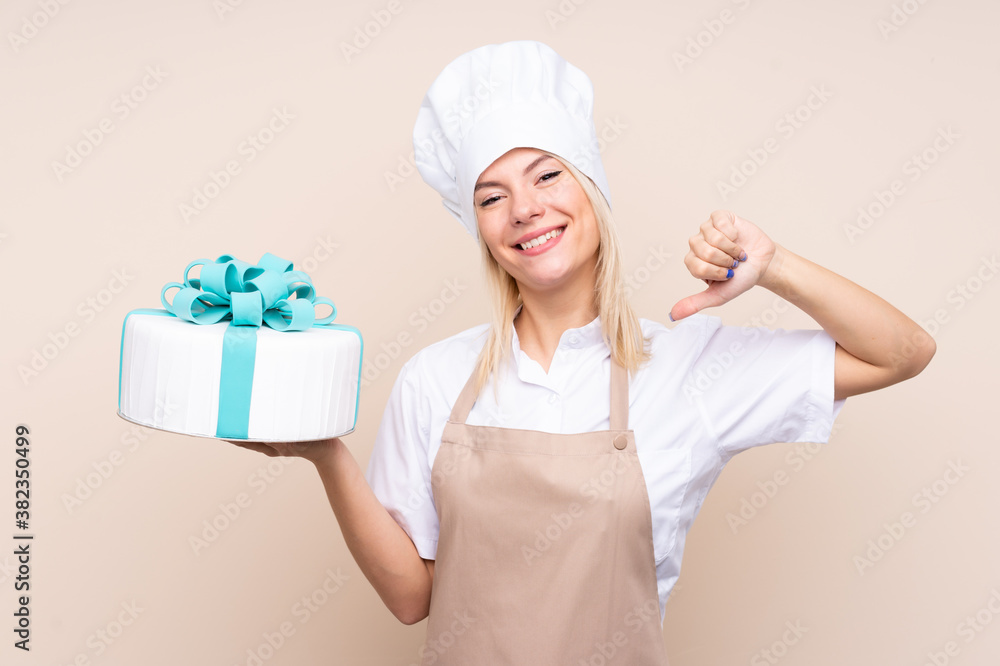Young Russian woman with a big cake over isolated background proud and self-satisfied Young Russian woman with a big cake over isolated background proud and self-satisfied