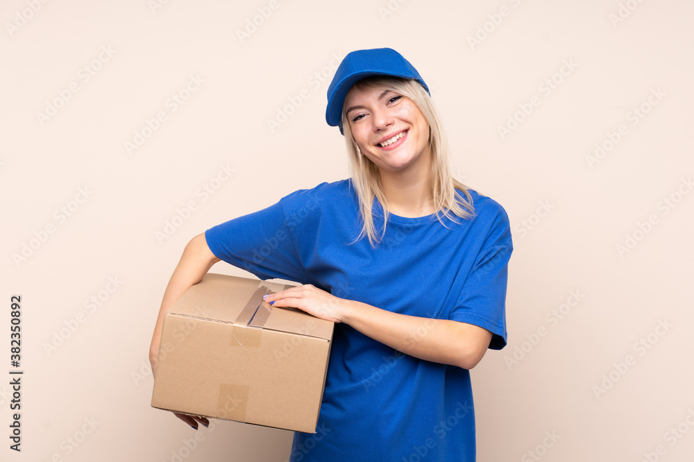 Young delivery woman over isolated background laughing Young delivery woman over isolated background laughing