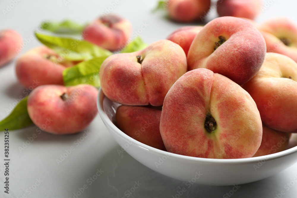 Fresh ripe donut peaches in bowl on light table, closeup Fresh ripe donut peaches in bowl on light table, closeup