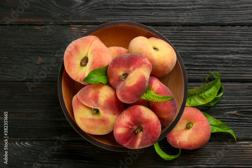 Fresh ripe donut peaches on black wooden table, flat lay
