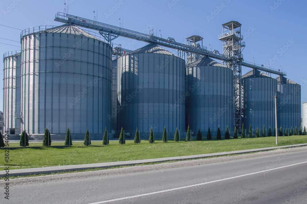 Granary. A large modern agro-processing plant for the storage and processing of grain crops. Large metal barrels of grain. Granary elevator. Horizontal image.