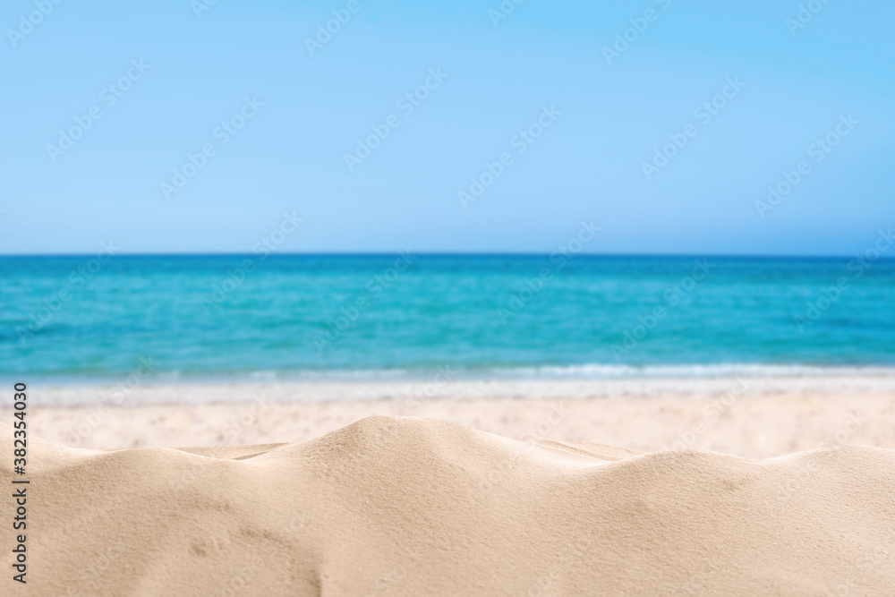 Beautiful sandy beach near sea under blue sky