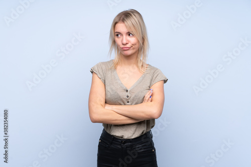 Young blonde woman over isolated blue background thinking an idea