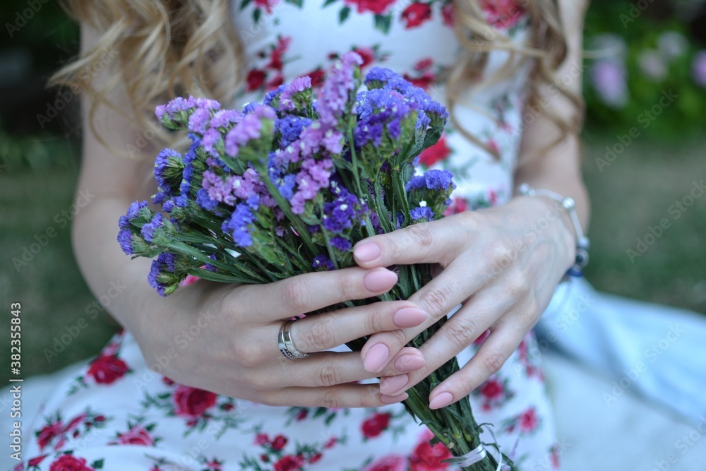 Fototapeta premium Very nice young woman holding beautiful bouque. Cropped photo, bouquet close up