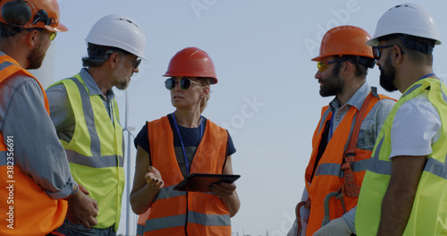 Female engineer speaking with male colleagues