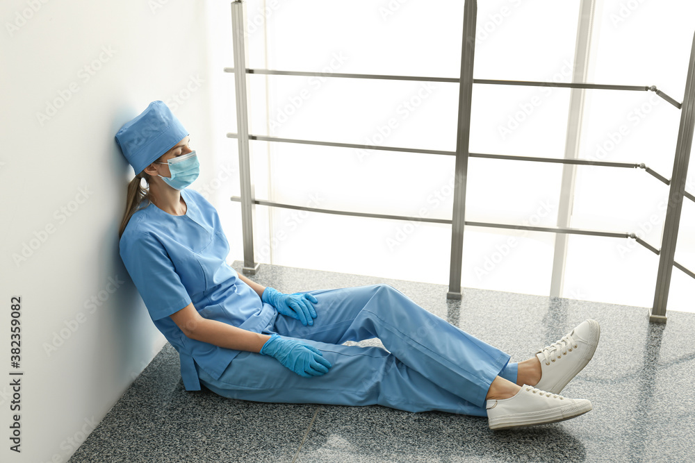 Exhausted doctor indoors. Stress of health care workers during COVID-19 pandemic Exhausted doctor indoors. Stress of health care workers during COVID-19 pandemic