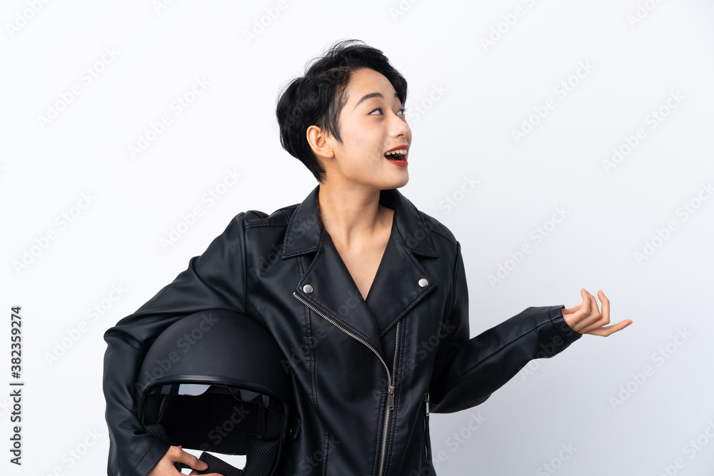 Young Asian girl with a motorcycle helmet over isolated white background with surprise facial expression Young Asian girl with a motorcycle helmet over isolated white background with surprise facial expression