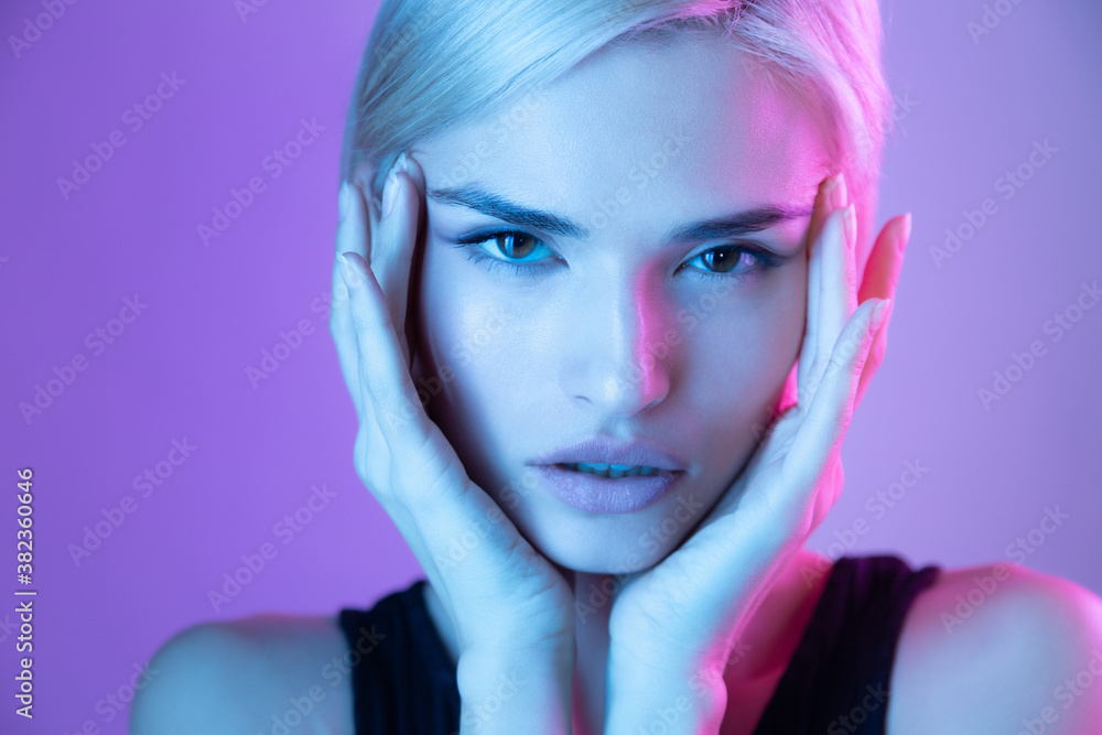 Fashion beauty portrait of beautiful girl with natural makeup and glowing facial skin in neon light Fashion beauty portrait of beautiful girl with natural makeup and glowing facial skin in neon light