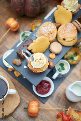 A beautiful gourmet selection of english afternoon tea cakes and scones served with organic cupcakes, tea and coffee, strawberry jam and clotted cream. traditional british food.