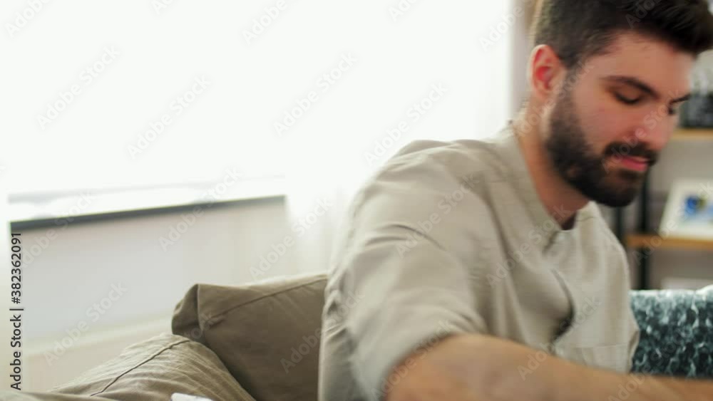 planning and people concept - man writing to notebook and drinking coffee at home planning and people concept - man writing to notebook and drinking coffee at home