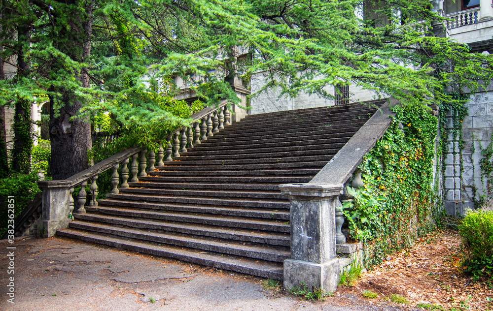 Ancient staircase with stone balusters on a background of green vegetation Ancient staircase with stone balusters on a background of green vegetation