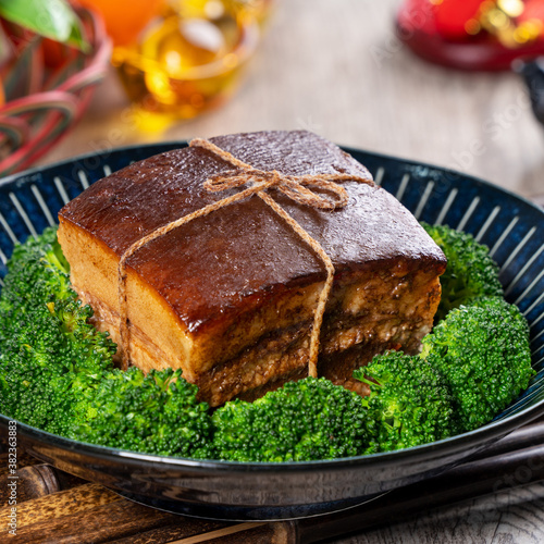 Dong Po Rou (Dongpo pork meat) in a plate with green vegetable, traditional festive food for Chinese lunar new year cuisine meal, close up. photo