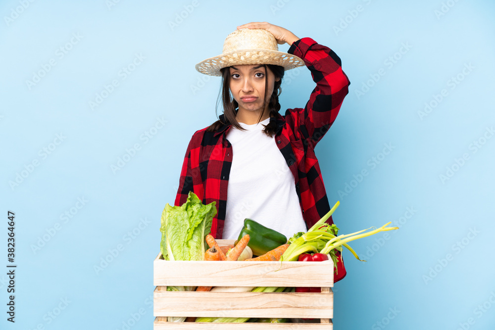 Young farmer Woman holding fresh vegetables in a wooden basket with an expression of frustration and not understanding