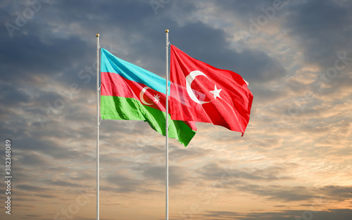 Azerbaijan and Turkey flags waving in the dawn sky. Symbol of international agreement and support during Karabakh war conflict with Armenia.