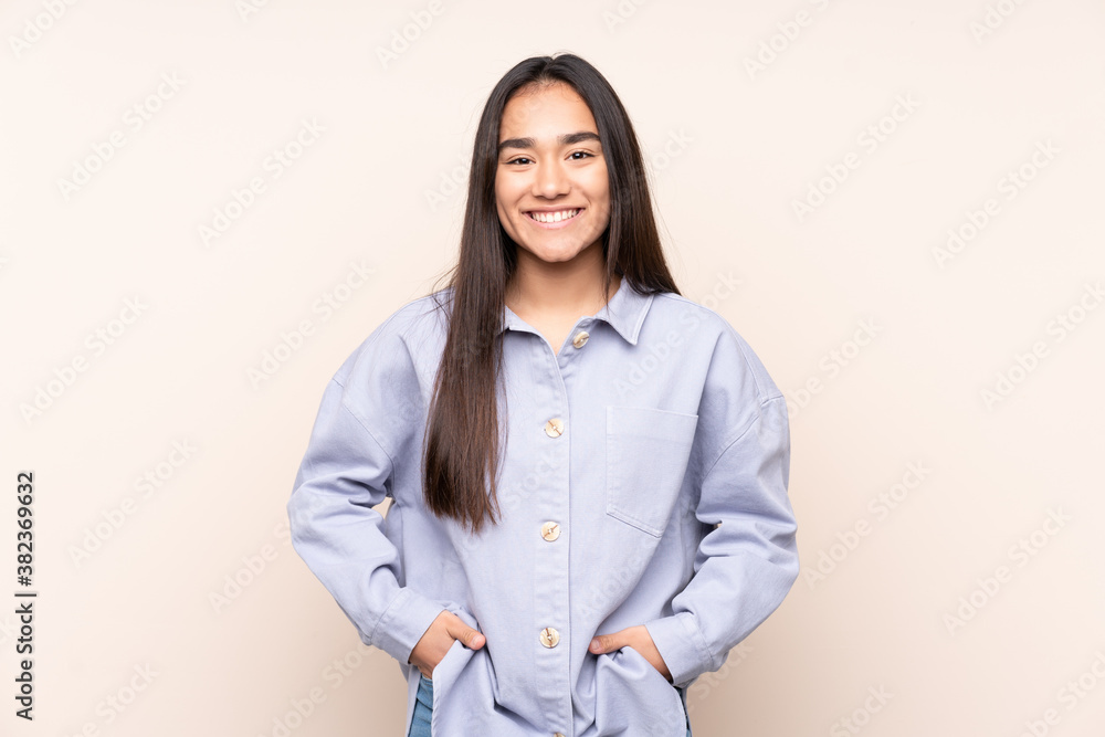 Young Indian woman isolated on beige background laughing Young Indian woman isolated on beige background laughing