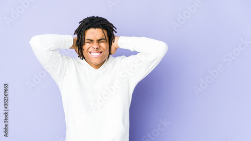 Young african american rasta man covering ears with hands trying not to hear too loud sound.