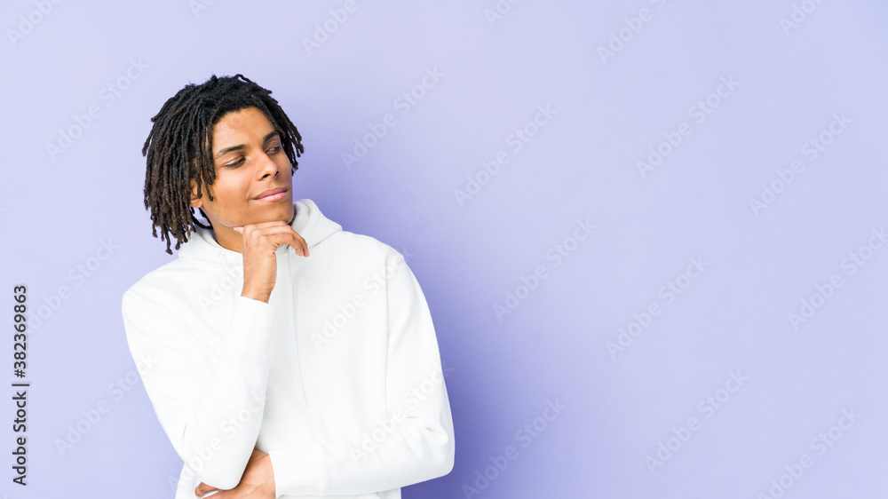 Young african american rasta man looking sideways with doubtful and skeptical expression. Young african american rasta man looking sideways with doubtful and skeptical expression.