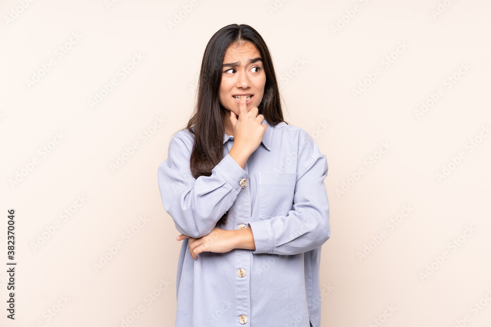 Young Indian woman isolated on beige background nervous and scared Young Indian woman isolated on beige background nervous and scared