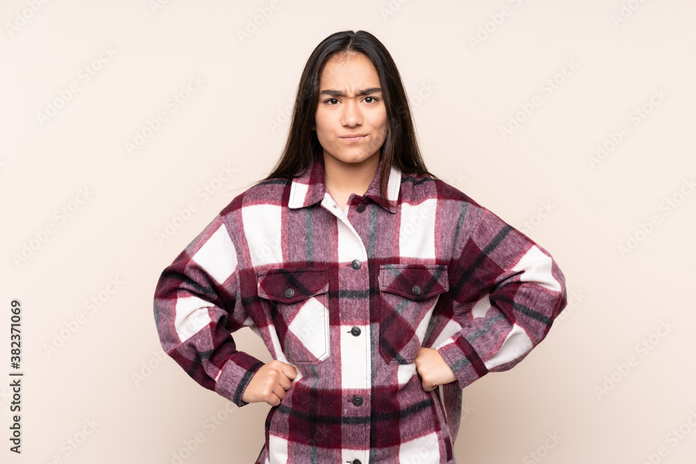 Young Indian woman isolated on beige background angry Young Indian woman isolated on beige background angry