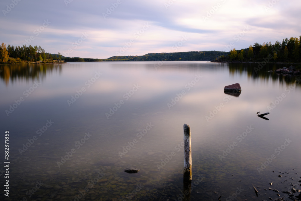Long exposure photo of poles protruding from the sea Long exposure photo of poles protruding from the sea
