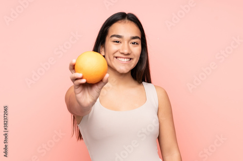 Young Indian woman holding an orange