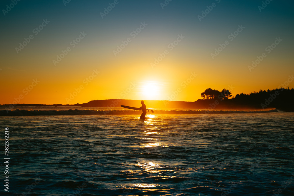 Surfing at sunset on the Ocean in Spain
