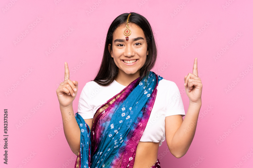 Young Indian woman with sari over isolated background pointing up a great idea Young Indian woman with sari over isolated background pointing up a great idea