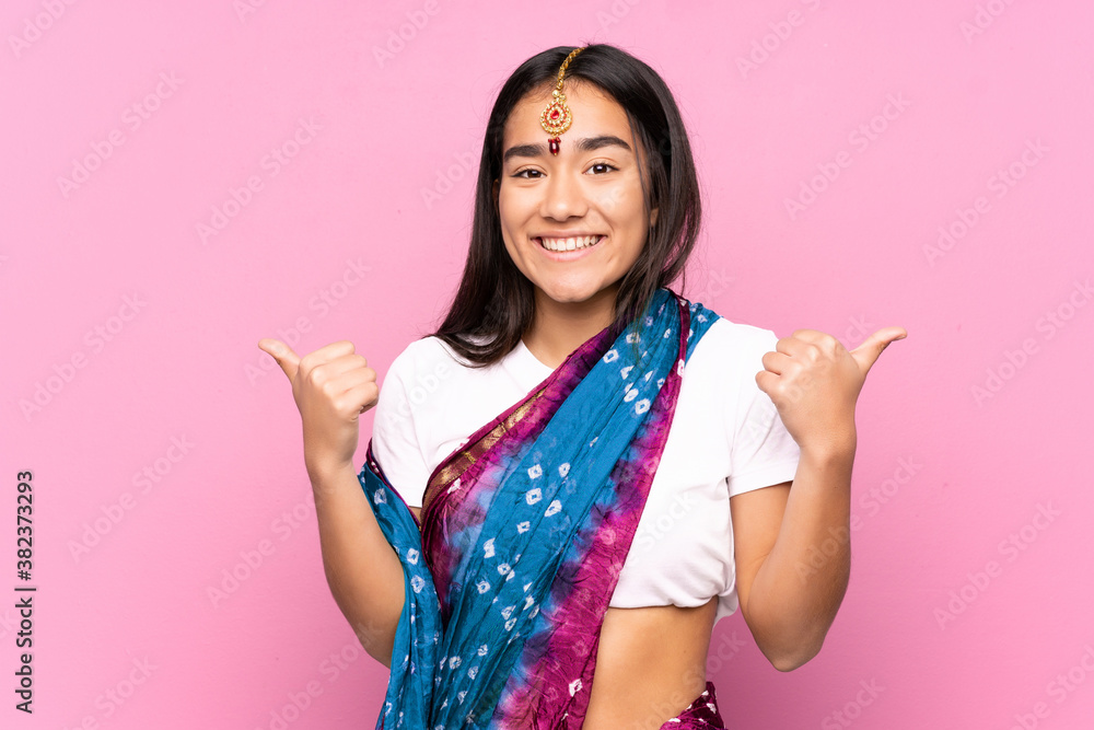 Young Indian woman with sari over isolated background with thumbs up gesture and smiling Young Indian woman with sari over isolated background with thumbs up gesture and smiling