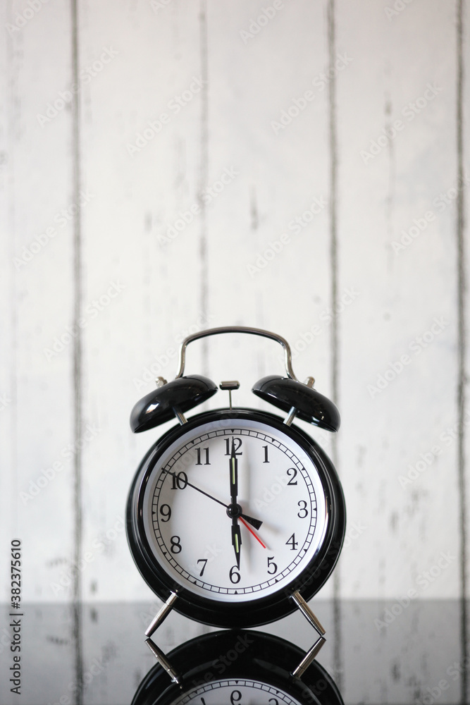 Alarm clock on table, black glass table. wake up time, 6 a.m, background Alarm clock on table, black glass table. wake up time, 6 a.m, background
