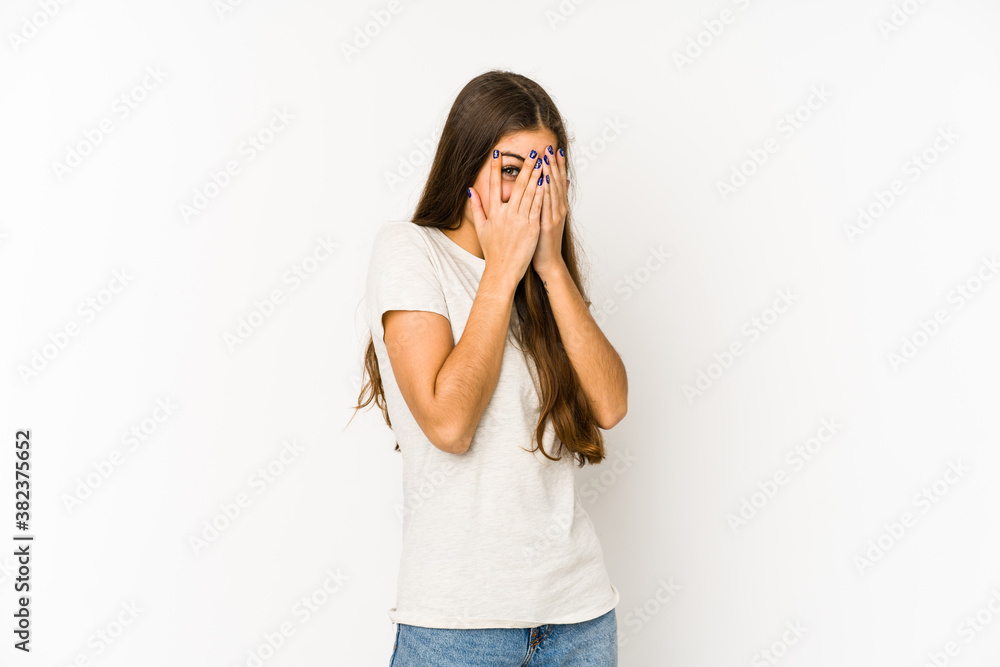 Young caucasian woman isolated on white background blink through fingers frightened and nervous. Young caucasian woman isolated on white background blink through fingers frightened and nervous.