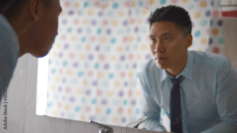 Close up of asian businessman washing face in bathroom Close up of asian businessman washing face in bathroom